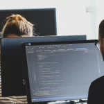 Developers on a laptop producing php code