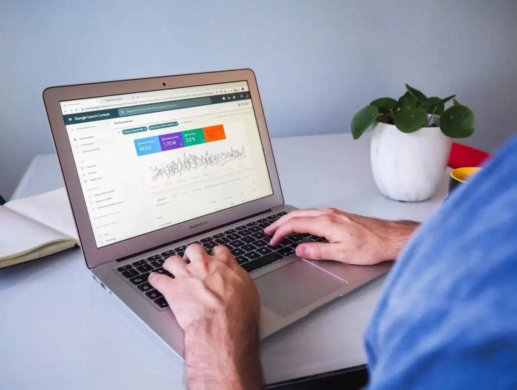 Modern laptop on an office desk displaying e-commerce growth analytics charts and SEO data graphs