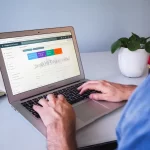 Modern laptop on an office desk displaying e-commerce growth analytics charts and SEO data graphs